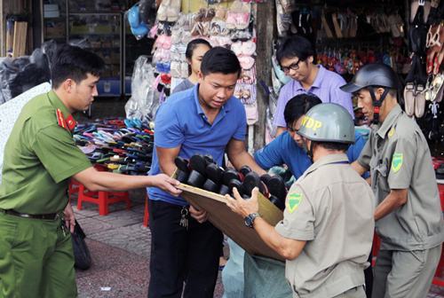 Lực lượng chức năng thu một sạp dép bày trên vỉa hè. Ảnh: Duy Trần